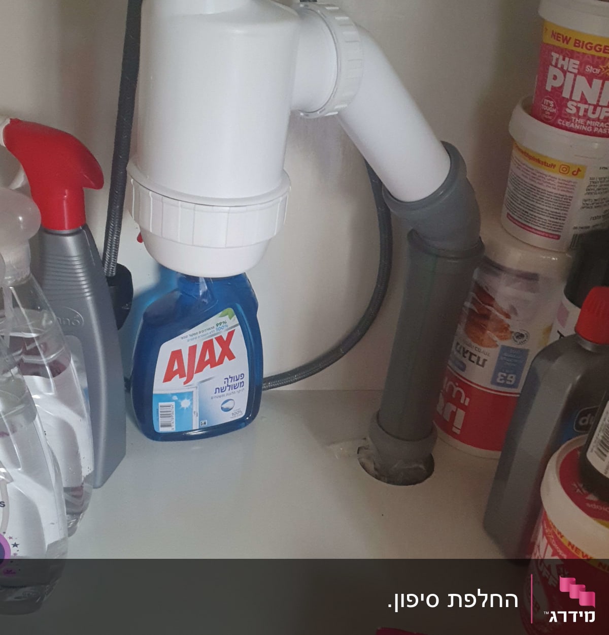 צינור ניקוז לבן מתחת לכיור עם חיבורים